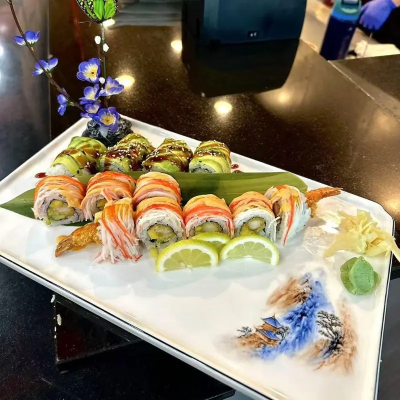 Colorful sushi rolls with shrimp tempura and avocado, attractively presented.