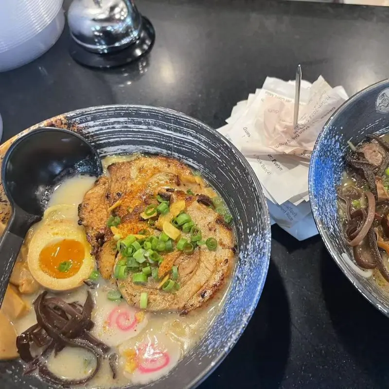 Ramen soup with pork chashu, soft - boiled egg, and seaweed.